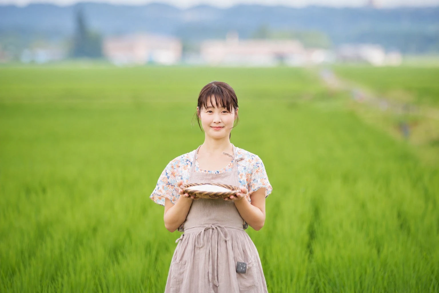 田んぼを背景に、ざるを持つすずめ